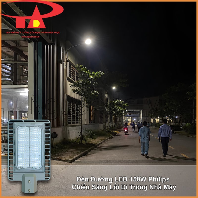 Lối đi trong nhà máy vào ban đêm với người đi bộ, xe máy và đèn đường bố trí dọc tuyến