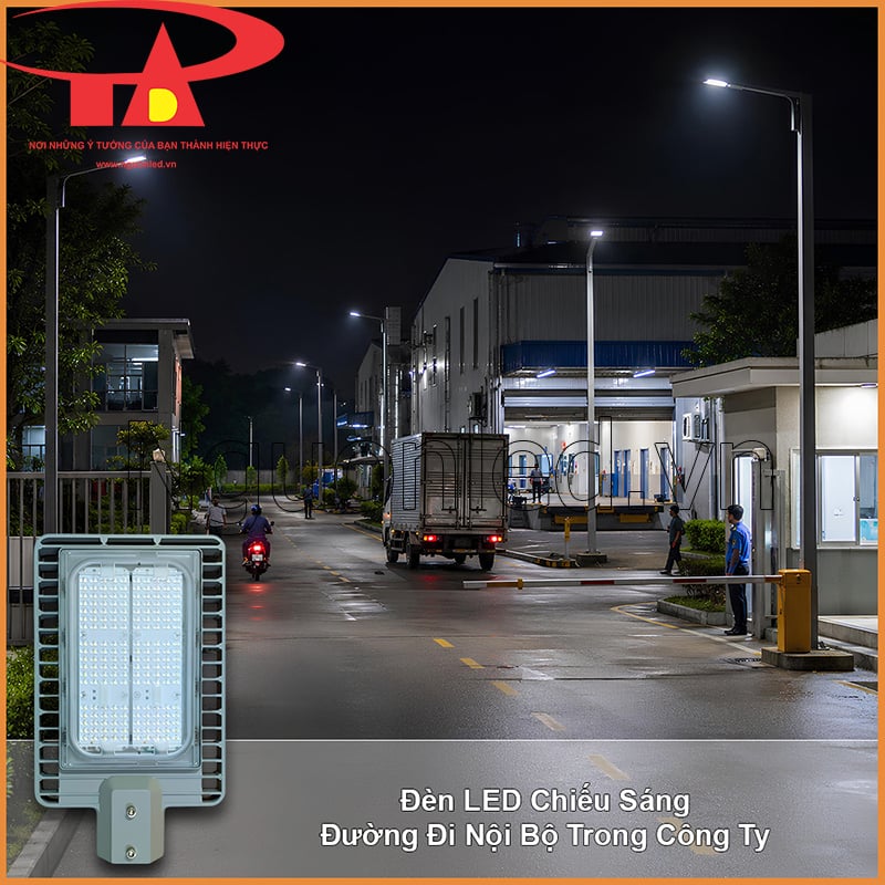Đường nội bộ công ty từ cổng vào khu vận hành với xe tải, xe máy và chốt bảo vệ vào ban đêm