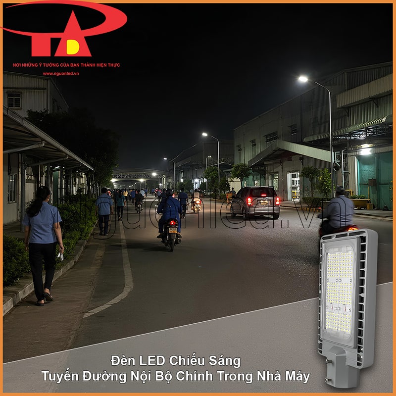 Tuyến đường nội bộ nhà máy vào giờ giao ca với công nhân, xe máy và ô tô dưới ánh đèn đường