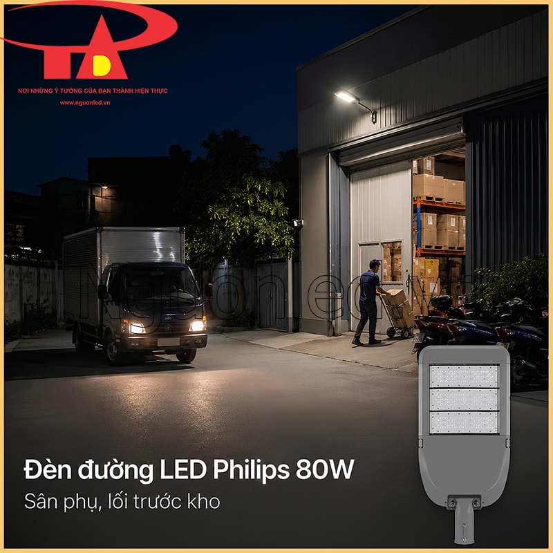 Đèn đường LED 80W chiếu lối trước kho vào ban đêm, có xe tải nhỏ, hàng hóa và xe máy gần cửa