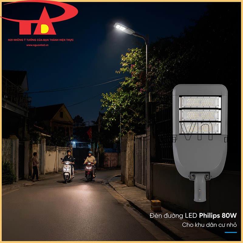 Đèn LED đường phố 80W chiếu đường nhánh gần nhà dân vào ban đêm, có người đi bộ và xe máy