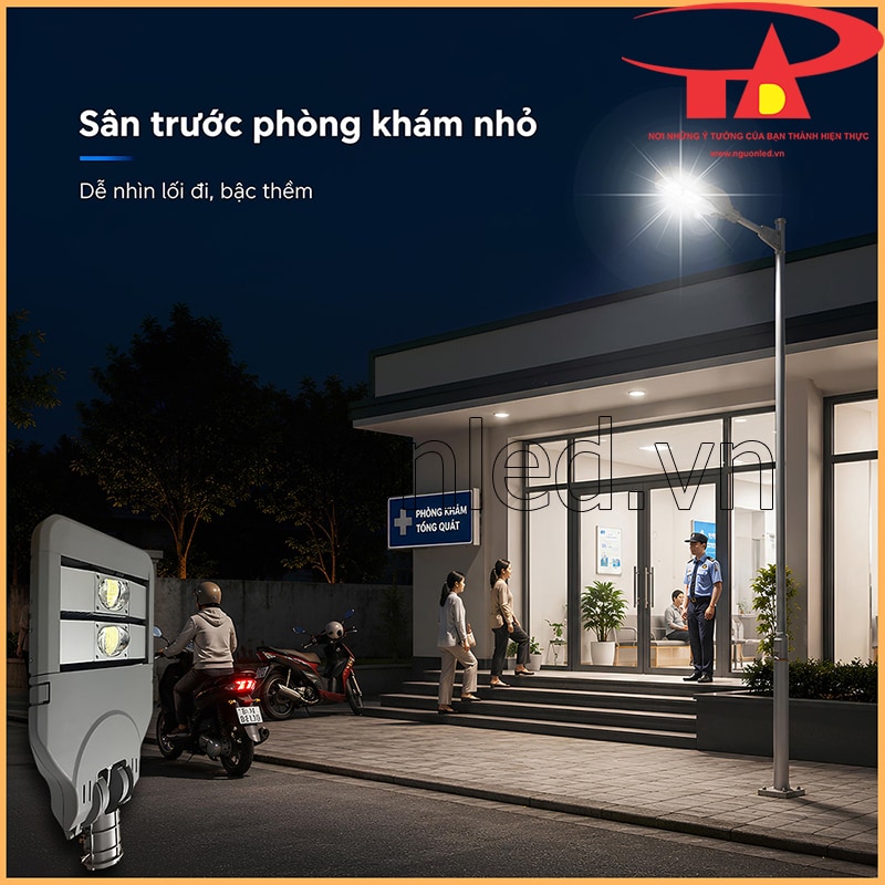 Đèn đường Philips 100W chiếu sân trước phòng khám nhỏ, có bậc thềm, xe máy, bảo vệ và người ra vào