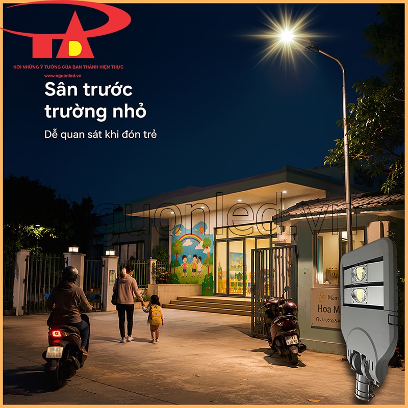 Đèn LED đường phố 100W chiếu sân trước trường mầm non, có cổng, phụ huynh, trẻ nhỏ và xe máy